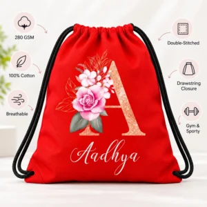 Red personalized kids drawstring bag with Aadhya floral design and callouts for 280 GSM, 100% cotton, breathable fabric, double stitching, and drawstring closure.