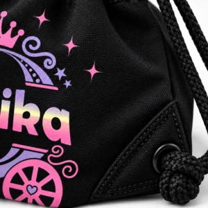 Close-up of black personalized kids drawstring bag showing woven fabric, stitched drawstring channel, black braided cord, reinforced corner and Eshika print.