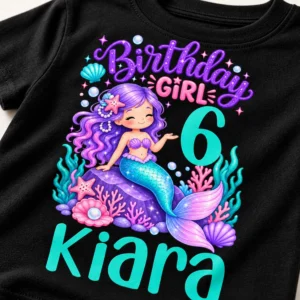 Close-up of a personalized birthday girl kids t-shirt print showing a mermaid design, number 6, and the name Kiara on black fabric.