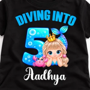 Close-up detail of a personalized black kids birthday t-shirt showing the "Diving Into 5" mermaid print and the name Aadhya.