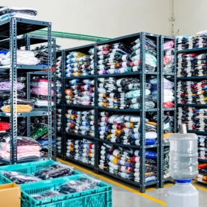 Organized shelves filled with packaged apparel inventory inside Printgen's production house warehouse.