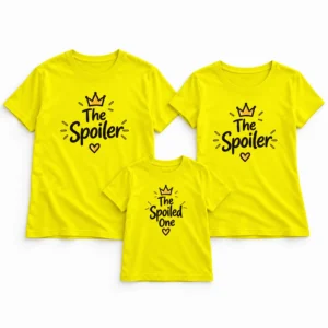 Flat-lay arrangement of three bright yellow matching family T-shirts, with two adult The Spoiler designs and one smaller children's The Spoiled One design featuring black lettering, crowns, and hearts.